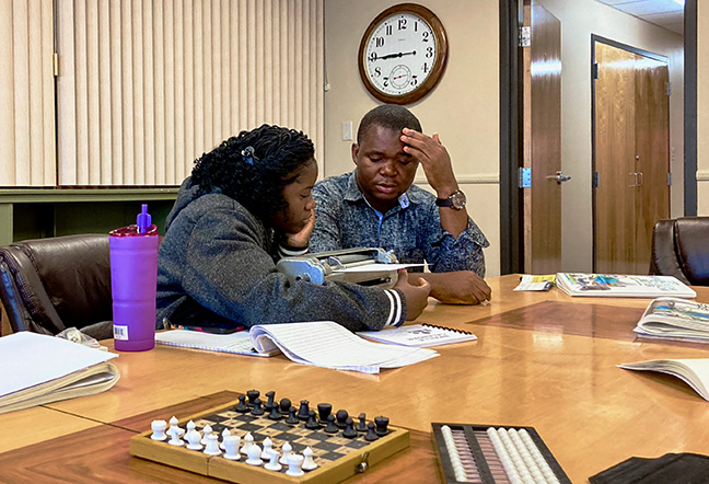 Our guests were diligent learners, but especially in their Braille class. Suahibu and Miatta examine a Braille page on a Perkins Brailler.