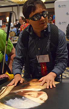 Charles Ny checks out one of John Olsen&rsquo;s tactile artworks in the Exhibit Hall.