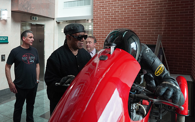 Stevie Wonder, his staff, and Mark Riccobono explore the Dan Parker &ldquo;Quest for the Salt&rdquo; motorcycle exhibit.