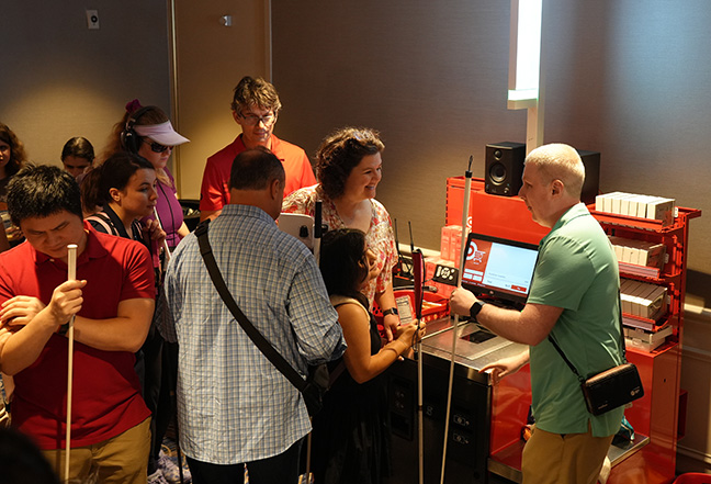 A crowd of members wait to try out the Target accessible check out. Steve Decker assists Kris Shields and her daughter Cindy as they test out the demo.