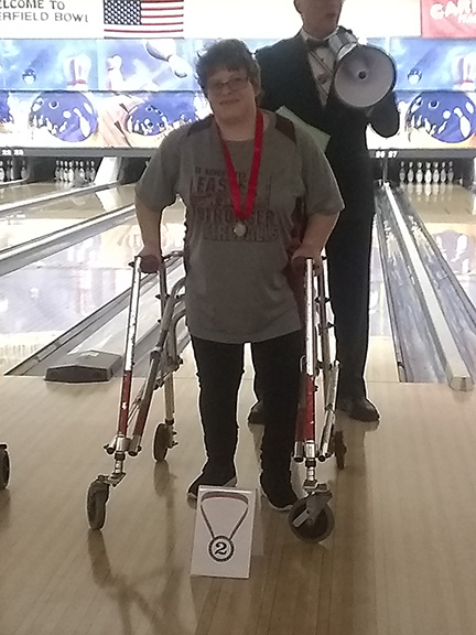 Crystal is pictured receiving a silver medal for bowling.