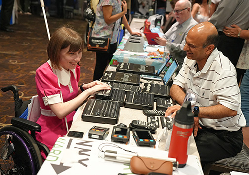 Ellana Crew tries out a Braille Notetaker at the Orbit booth in the national convention exhibit hall.
