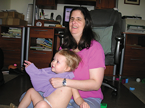 Jo Pinto helps her daughter get dressed.&nbsp;