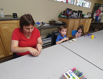 Ronit Mazzoni and her children play with Playdough.