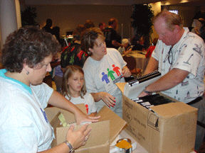 UPS volunteers from the Georgia office, Patty Conley (left), Christie Davis (middle), and Christie's daughter, Morgan, work with NOPBC volunteer, Bob Brackett (Florida), to box up Braille books to ship Free Matter to the homes of their new owners.