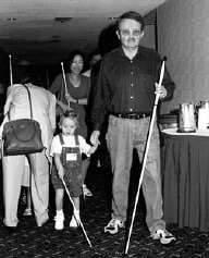 Mike Neese, a former student at the Louisiana Tech/Louisianna Center for the Blind O&M program, and four year old Jodi Jones pair up at the Cane Walk
