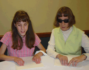 Barbara Loos (right) and Anna Schuck of Michigan, read Braille together at the 2005 NFB Braille Carnival.