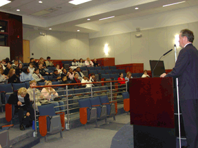 NFB President Marc Maurer addresses a group of students from the stage of the auditorium in the NFB Jernigan Institute.