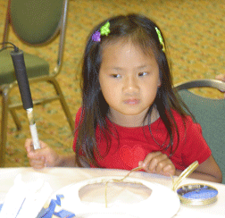 Ahbee, daughter of Joy Orton, listens carefully to instructions from her mentor at the Braille Carnival.