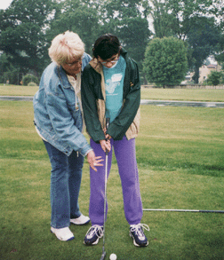 Lex Wallerstein gets a quick putting lesson from Barbara Peluso.