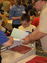 J.W. Frampton, age 8, (Rhode Island), sorts through a stack while his father, John, tries to keep up.