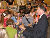 Dr. Maurer and the children in the room gather to talk about blindness