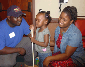 In order to travel safely and efficiently, the cane should be long enough to detect objects well in advance of the traveler. Here, Kayla Harris stands with a cane that reaches just under her nose, as she shares a moment with her parents, Kevin Harris and Sharonda Baker, of Maryland.