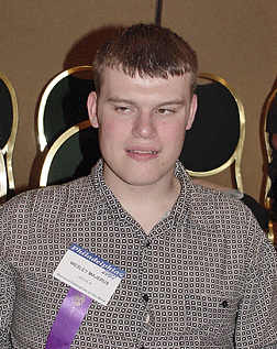 This 2001 convention photo shows Wesley Majerus wearing the purple ribbon proclaiming his status as an NFB Scholarship winner. Today, following successful employment with the state of Nebraska, he is a member of the NFB staff in Baltimore, Maryland.