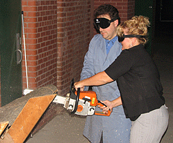 Noah�s mom (Misty Davis�NC) cuts through her own fear�s, too, at the 2008 Junior Science Academy. Mark Riccobono, director of the NFB Jernigan Institute (who is himself blind) is the patient instructor who guides her successfully through the experience of using a chainsaw to cut a section of a log while under sleepshades.