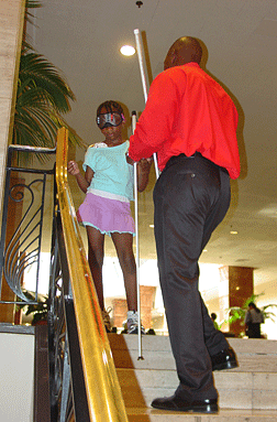 The Cane Walk has become one of the highlights of the convention for many kids and their families. At the 2006 convention in Dallas, Roland Allen shows Nautica Whitehead how she can safely maneuver steps.