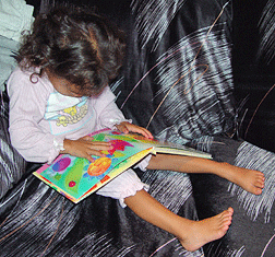 Milagro, age three, feels very grown up as she &ldquo;reads&rdquo; Ten Little Ladybugs with Braille labels.