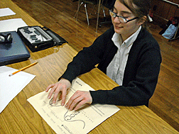 A well-rounded education requires skills in using and interpreting graphics. This St. Lucy student carefully examines a tactile graphic for a homework assignment.