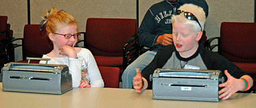 Megan (left) compares notes with her friend, Austin Fowler, at the 2005 Braille Challenge.