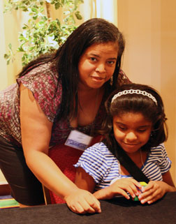 March&eacute; Daughtry works a Brailled Rubik&rsquo;s Cube while her mother, Zina Lewis, looks on.