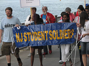 Marchers carrying a huge banner that reads &ldquo;NJ Student Soldiers&rdquo; pass a smiling group of senior citizens holding a sign for the Arizona affiliate.