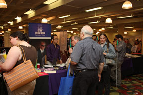 Visitors crowd around a table in the exhibit hall to examine the latest equipment from GW Micro.