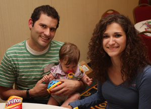Sariah and Jake Mattinson with baby Sydney sit together at Family Hospitality Night.