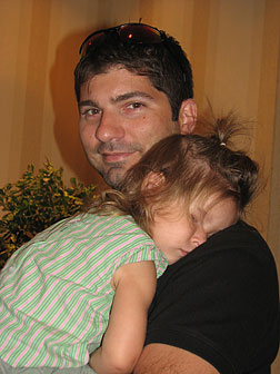 Convention can wear you out! At the end of a long day a toddler lies draped over her dad&rsquo;s shoulder, fast asleep.