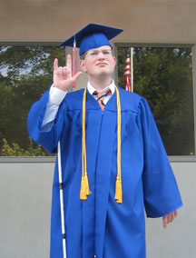 Wearing his commencement gown, Jon Gabry signs "I love you."