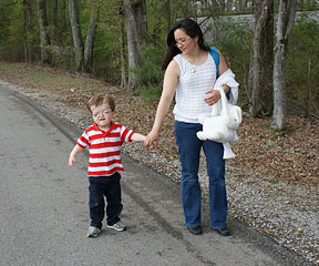 Jack and his mother walk along a road on a summer day.