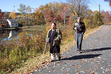 Steve Hastalis and student passing pond.