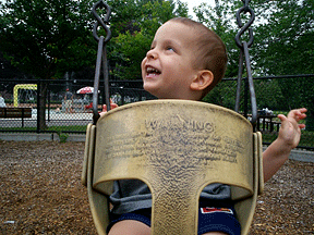 Ivan enjoys a swing in the park.