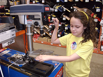 Kendra examines a drill press at Home Depot.