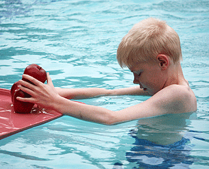 In the pool Luther Fuller balances three apples on a floating tray