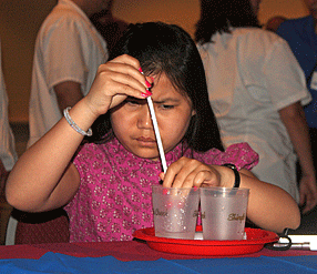Ashleah Chamberlain uses straw to transfer water from glass to glass