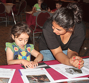 Julia Gebert reads the Braille label on an art room display table