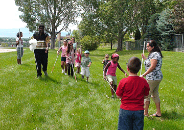 A group of blind kids explore a grassy area.