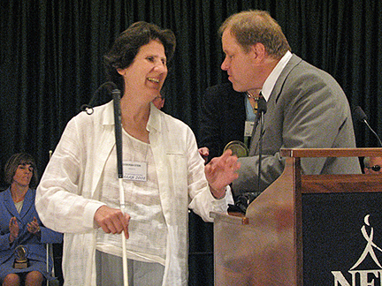 At the podium Gary Wunder shakes hands with Deborah Kent Stein. 