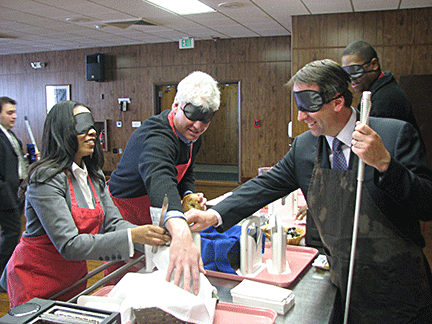 Teens and mentors set up a breakfast table while wearing sleepshades.