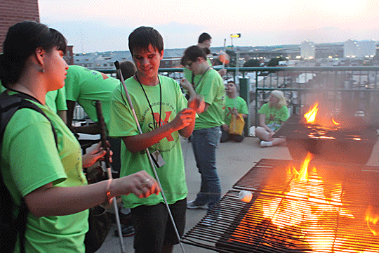 Students in the NFB STEM-X program grill marshmallows over a roaring fire.