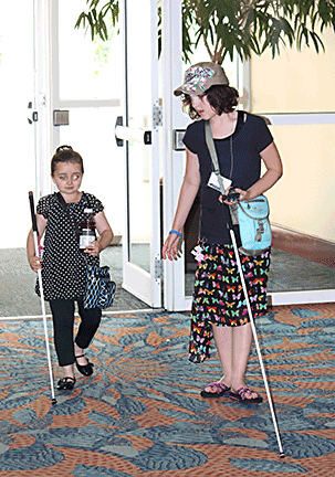 Canes in hand, Julia Gebert and Abby Duffy walk down a hallway.