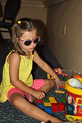 Layla Hildenbrand plays with blocks on the floor.