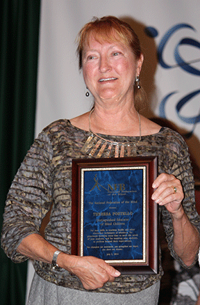 Theresa Postello holds her award plaque.