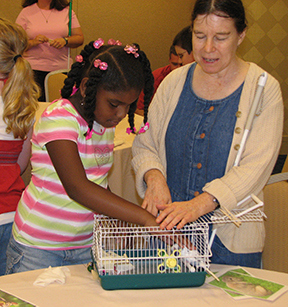 Heather Field shows a bird to a blind child.
