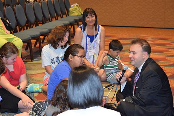 Mark Riccobono sits on the floor in a circle of blind children. See Kid Talk article.