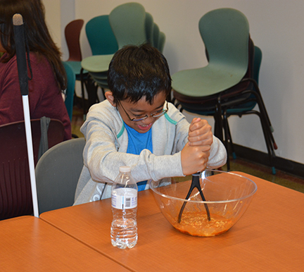 Jalen Yu mixes ingredients in a bowl during the “Stomach This” session at STEM2U Phoenix.