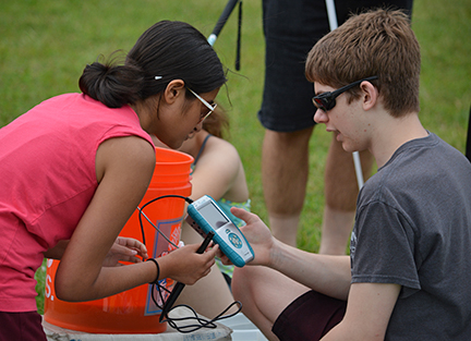 Mausam Mehta and Jamison Hunter test the PH of their water using a talking LabQuest meter at STEM EQ.