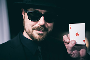Chad Allen holds up the ace of hearts.