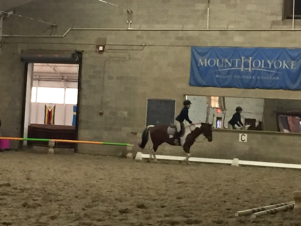 Melissa Carney rides horseback in an indoor ring.