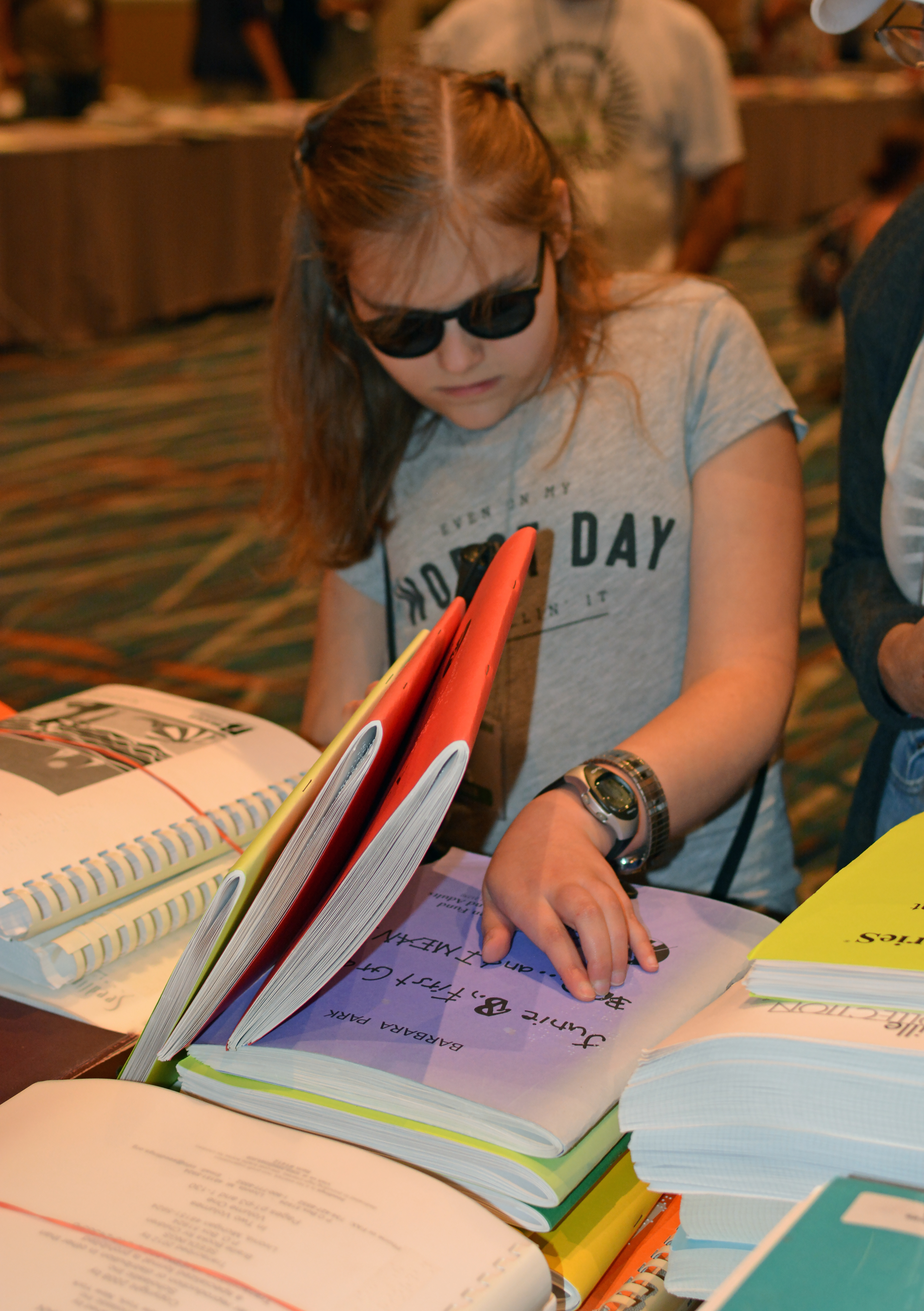 Hailey Baskeyfield sorts through a pile of Braille books.